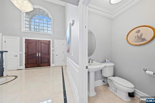 bathroom featuring ornamental molding, tile patterned floors, and toilet