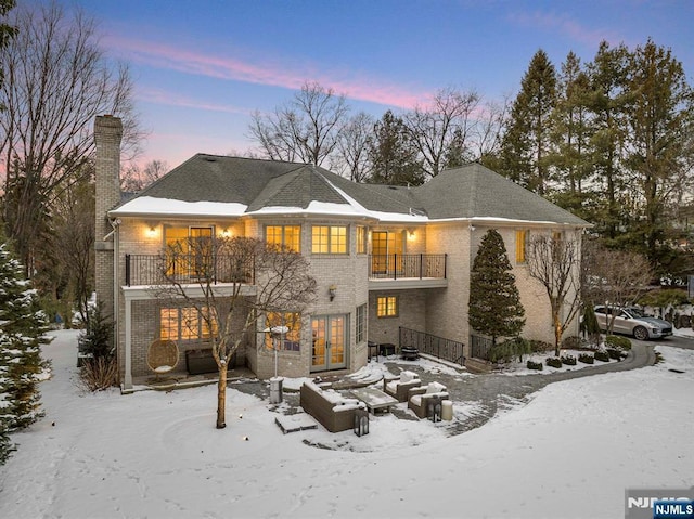 snow covered property with a balcony