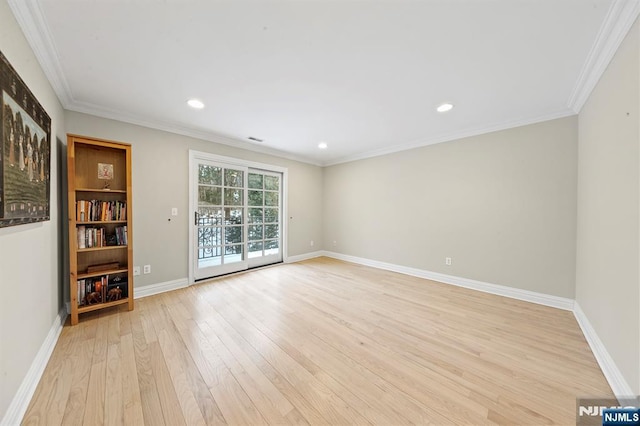 spare room with ornamental molding and light hardwood / wood-style flooring