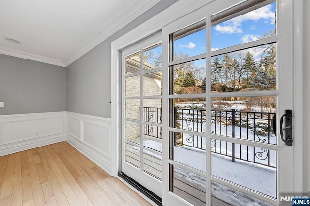 doorway with ornamental molding and light hardwood / wood-style flooring