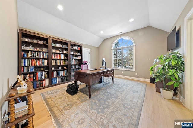 office space featuring lofted ceiling and light hardwood / wood-style flooring