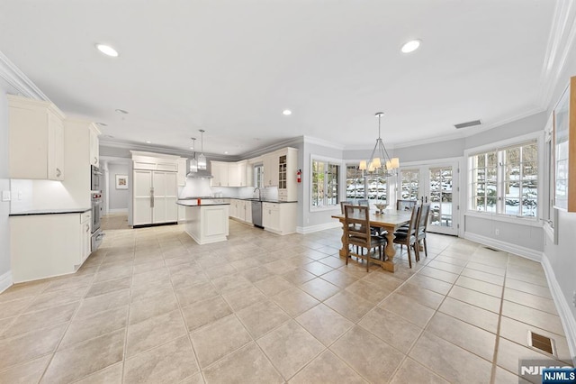 dining space with crown molding, light tile patterned floors, and an inviting chandelier