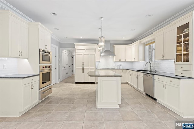 kitchen featuring sink, hanging light fixtures, a center island, stainless steel dishwasher, and wall chimney exhaust hood