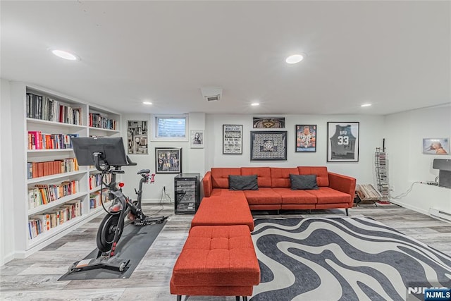 exercise area with light hardwood / wood-style flooring and a baseboard radiator