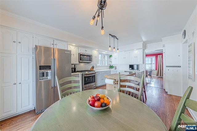 dining room featuring ornamental molding and hardwood / wood-style floors