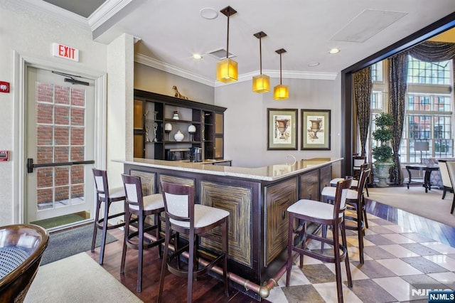 bar with ornamental molding and decorative light fixtures