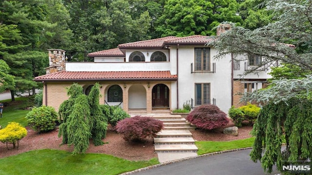 mediterranean / spanish home featuring a porch