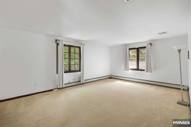 empty room with baseboard heating and light carpet