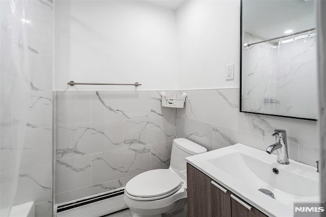 bathroom with tile walls, a baseboard heating unit, vanity, and toilet