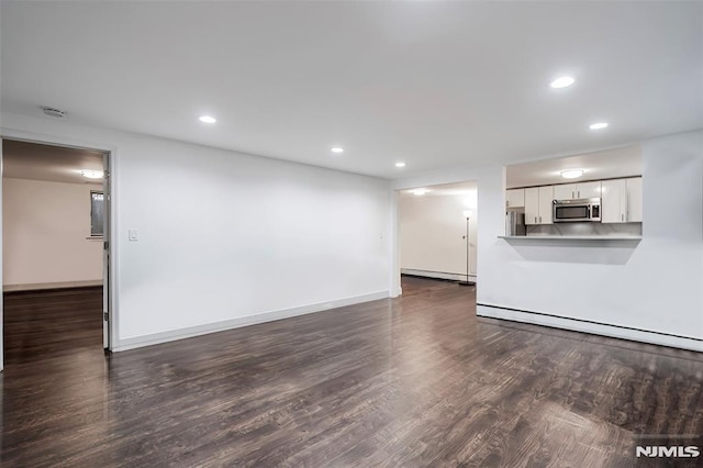 unfurnished living room with dark hardwood / wood-style floors and a baseboard radiator