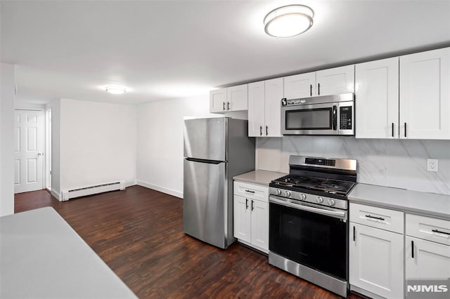 kitchen with white cabinets, baseboard heating, appliances with stainless steel finishes, and dark hardwood / wood-style floors