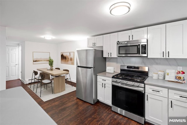 kitchen with baseboard heating, stainless steel appliances, dark hardwood / wood-style flooring, and white cabinetry