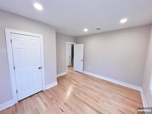 unfurnished bedroom featuring a closet and light wood-type flooring