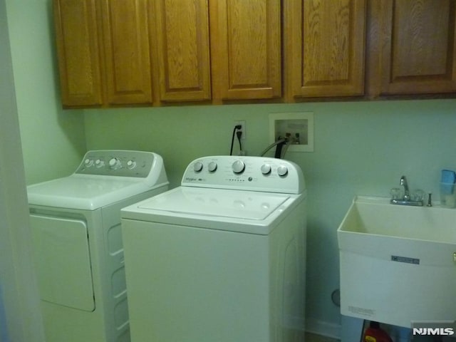 laundry area featuring sink, cabinets, and independent washer and dryer