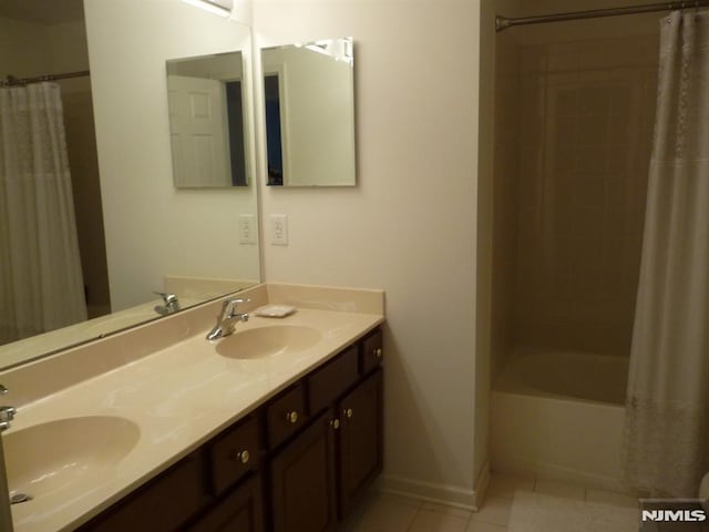 bathroom with shower / bath combo with shower curtain, tile patterned flooring, and vanity