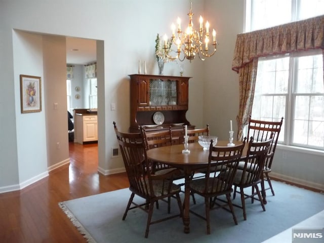 dining room featuring a notable chandelier and dark hardwood / wood-style flooring