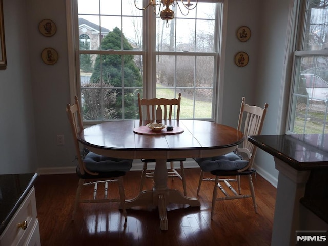 dining room with plenty of natural light, dark hardwood / wood-style floors, and a chandelier