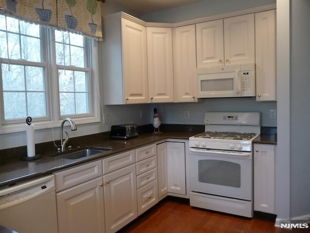 kitchen with white cabinetry, sink, white appliances, and dark wood-type flooring