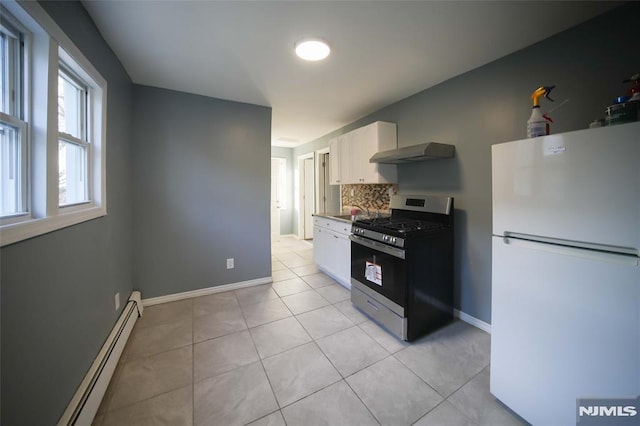 kitchen featuring white cabinetry, a baseboard heating unit, stainless steel gas stove, wall chimney range hood, and white refrigerator