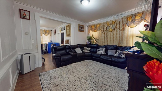 living room with dark wood-type flooring and ornamental molding