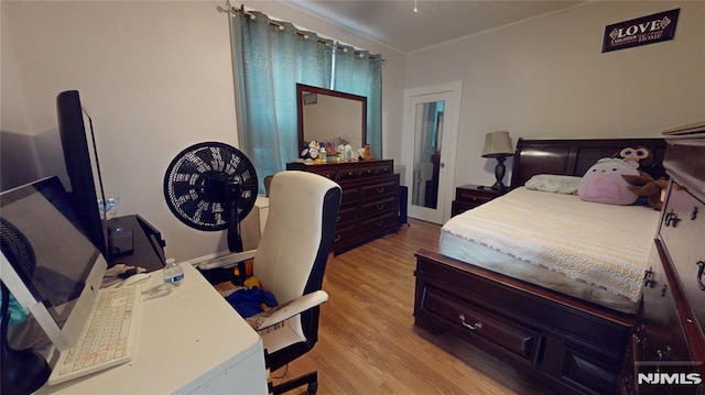 bedroom featuring ornamental molding and light hardwood / wood-style flooring