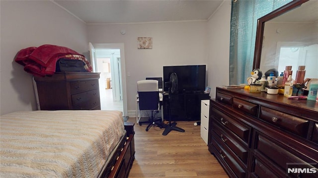 bedroom with light hardwood / wood-style floors and ornamental molding