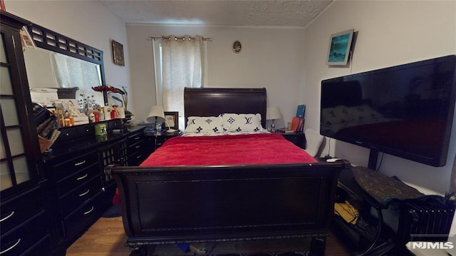 bedroom featuring a textured ceiling and wood-type flooring