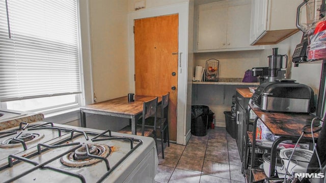 kitchen with stove and dark tile patterned flooring