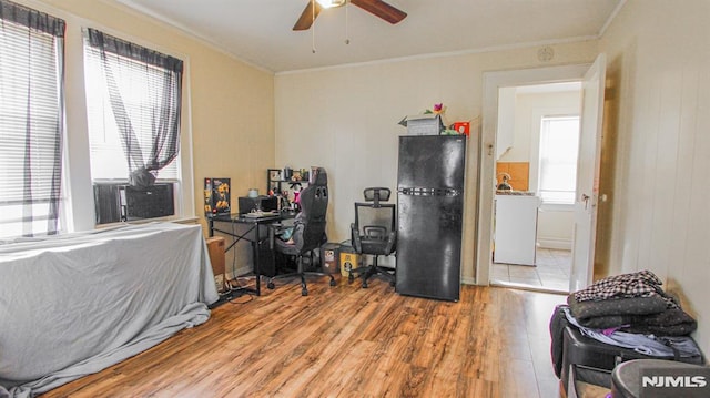 office space featuring ceiling fan, washer / dryer, ornamental molding, and light hardwood / wood-style floors