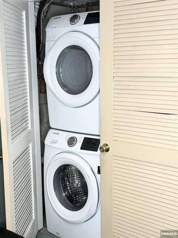 clothes washing area featuring stacked washer and dryer