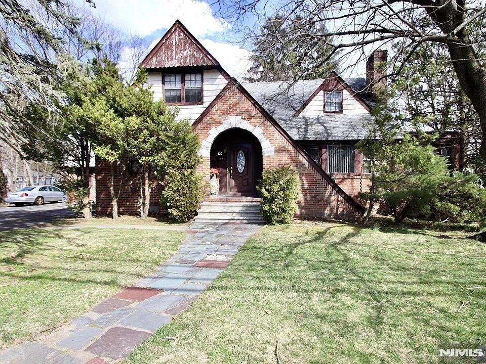 tudor-style house featuring a front lawn