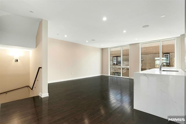 unfurnished living room with a fireplace, dark hardwood / wood-style flooring, and sink