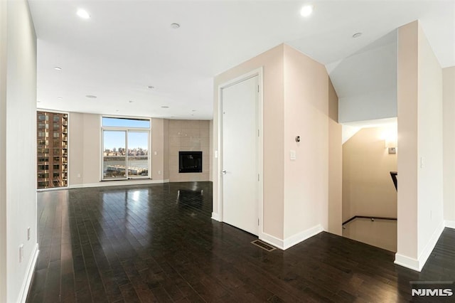 unfurnished living room featuring dark hardwood / wood-style flooring and a fireplace