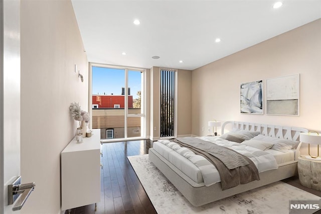 bedroom with hardwood / wood-style flooring and expansive windows