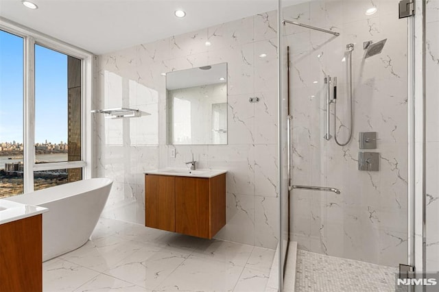 bathroom with vanity, shower with separate bathtub, floor to ceiling windows, and tile walls