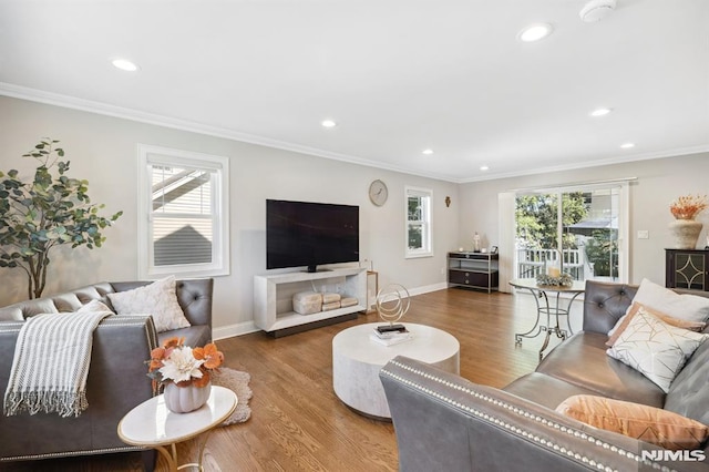 living room featuring a wealth of natural light, ornamental molding, and hardwood / wood-style flooring