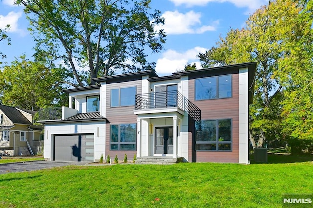 view of front of property with a front lawn, a balcony, and a garage