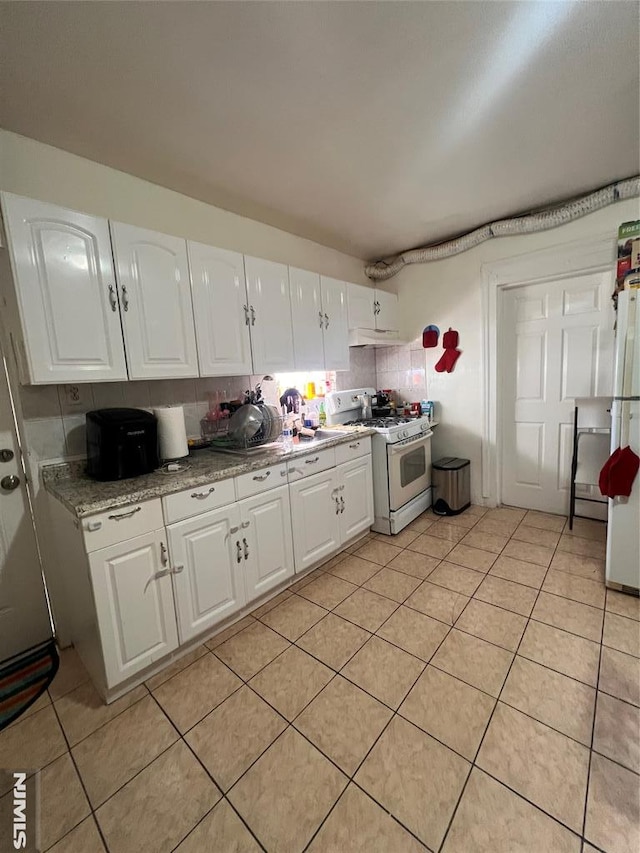 kitchen featuring light tile patterned floors, white cabinetry, and white appliances