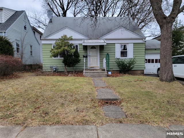 view of front of home with a garage and a front lawn