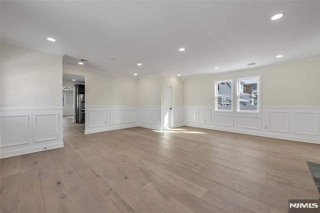 empty room featuring light hardwood / wood-style floors and ornamental molding