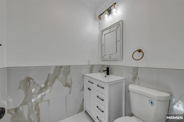 bathroom featuring tile walls, toilet, and vanity