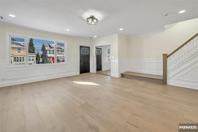 interior space with ornamental molding and light hardwood / wood-style floors