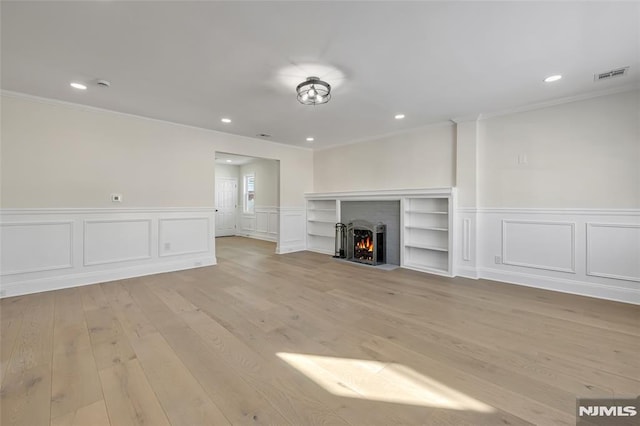 unfurnished living room with crown molding and light hardwood / wood-style flooring