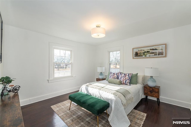 bedroom with dark wood-type flooring and multiple windows