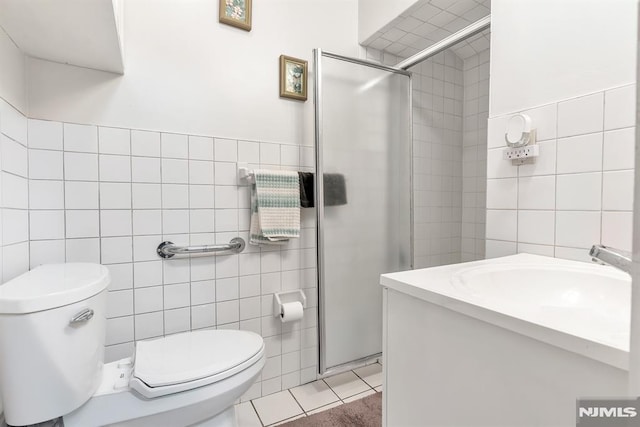 bathroom featuring toilet, tile walls, tile patterned floors, and a shower with shower door