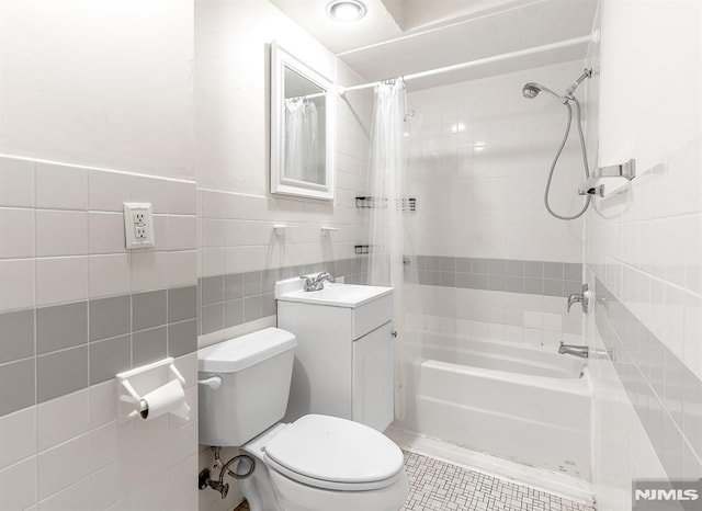 full bathroom with tile patterned flooring, vanity, tile walls, toilet, and shower / bath combo with shower curtain