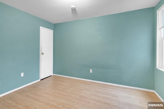 spare room featuring light hardwood / wood-style floors and plenty of natural light