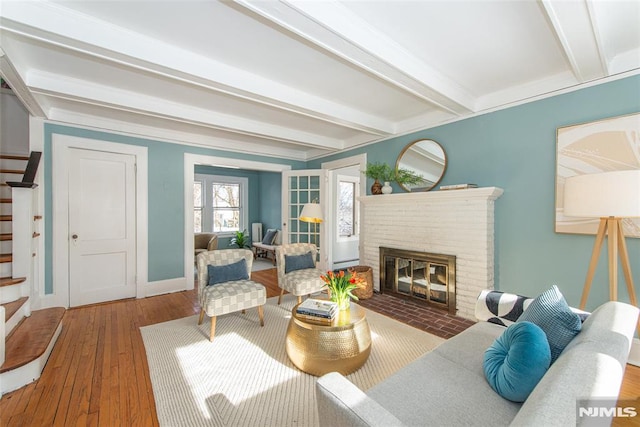 living room featuring hardwood / wood-style floors, beam ceiling, and a fireplace