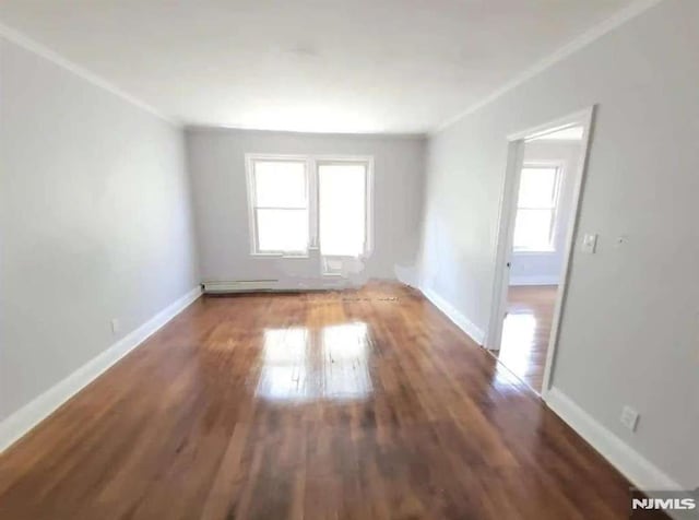 empty room with dark hardwood / wood-style floors and crown molding