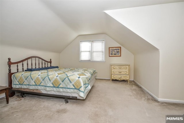 bedroom featuring lofted ceiling and carpet